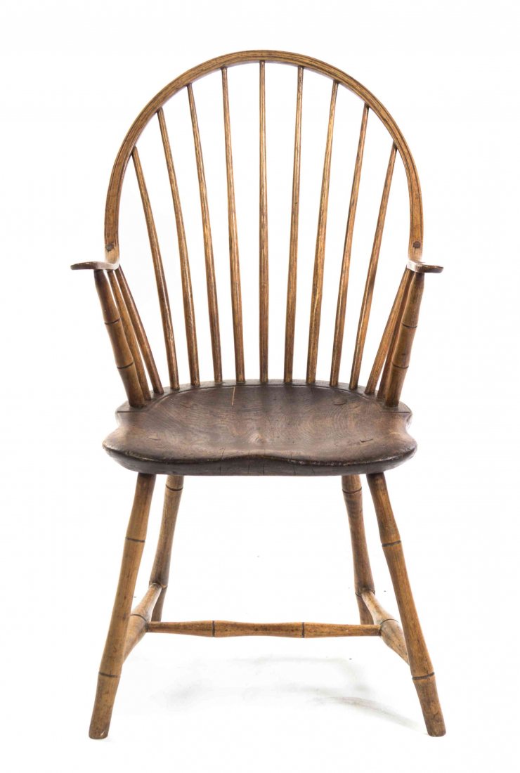 An American Oak Windsor Spindle Back Chair, Height 35: An American Oak Windsor Spindle Back Chair, having an arched crest rail joining shaped arms over a shaped seat, raised on turned legs joined by an H-form stretcher. Height 35 1/2 inches. Property from