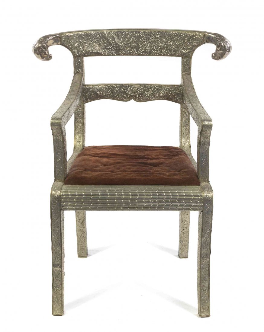 A Middle Eastern Silver Clad Open Armchair, Height 35: A Middle Eastern Silver Clad Open Armchair, having a curved crest rail with ram masks over a horizontal splat and drop-in cushion seat, raised on square legs. Height 35 inches. Property from the Colle