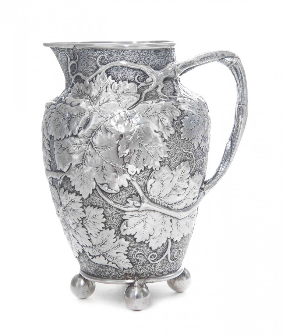 A Victorian Silver Pitcher, Height overall 8 1/4: A Victorian Silver Pitcher, Stephen Smith, London, 1872, tapered cylindrical, embossed and chased overall with scrolling grapevine and foliage against matted ground, with bi-furcated vine form handle,