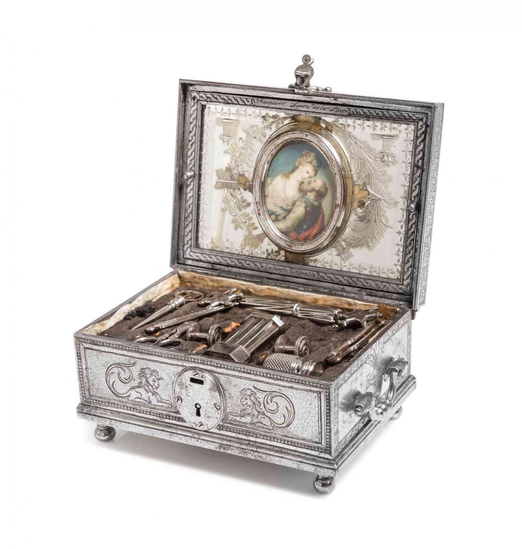 A Spanish Steel Sewing Case, Height 2 1/4 x width 4 3/4: A Spanish Steel Sewing Case, CIRCA 1800, comprising two needle cases, a scissor, two spools, two star form winders, a bodkin and other tools, together with a later thimble, mounted with an oval portra