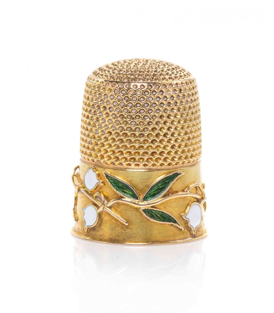 A Gold and Enamel Thimble, Height 3/4 inch.: A Gold and Enamel Thimble, AMERICAN OR ENGLISH, EARLY 20TH CENTURY, the lower body applied with a band of running foliage with translucent green enamel leaves and opaque white flower heads. Height 3/4
