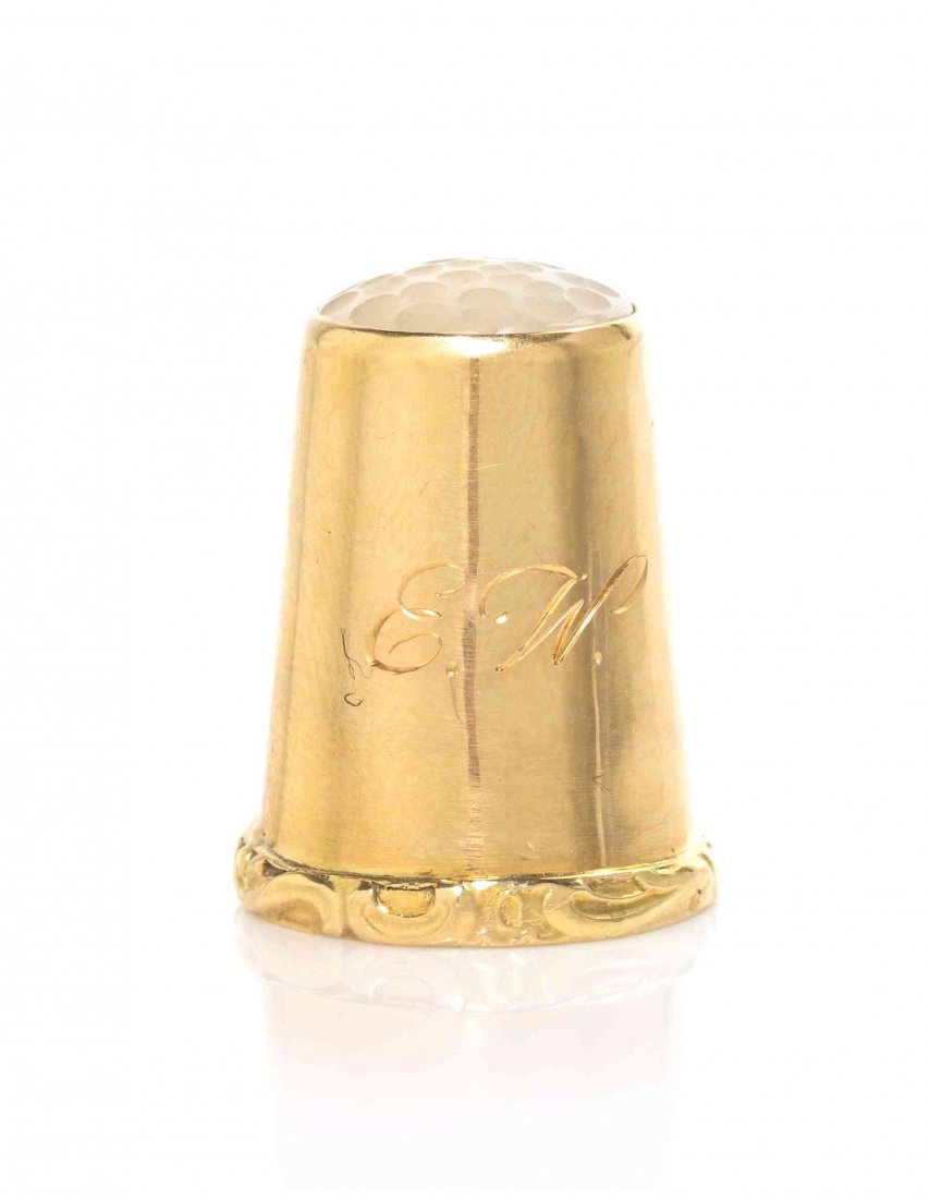 A Swedish Gold and Moonstone-Mounted Thimble, Height: A Swedish Gold and Moonstone-Mounted Thimble, 2ND HALF 19TH CENTURY, with plain tapered sides and applied scroll rim, the top with a faceted moonstone, engraved with script initials E.W., marked on in