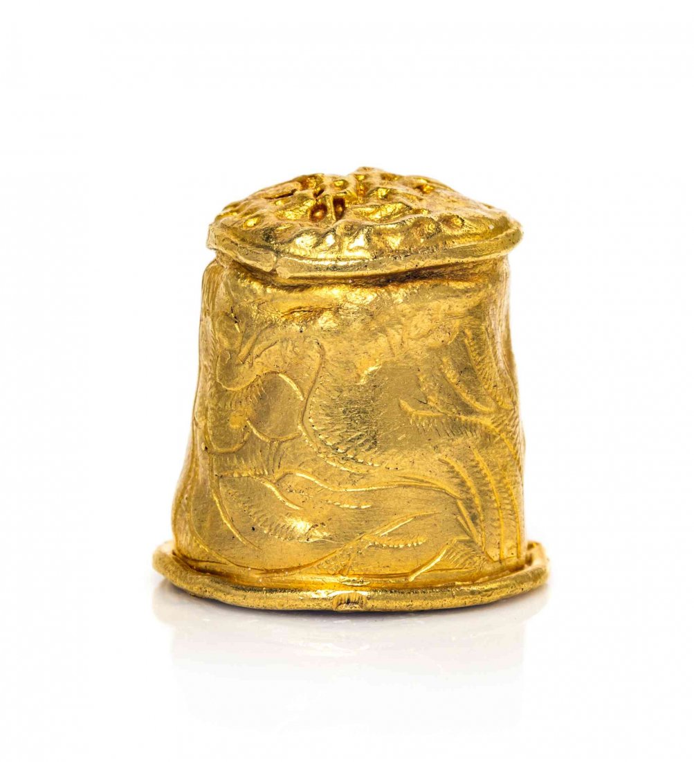 A South American Gold Thimble, Height 1/2 inch.: A South American Gold Thimble, POSSIBLY PERU, LATE 17TH CENTURY, the slightly tapered sides decorated with a large bird and flower amongst foliage, the top with irregular indentations, unmarked. Heigh