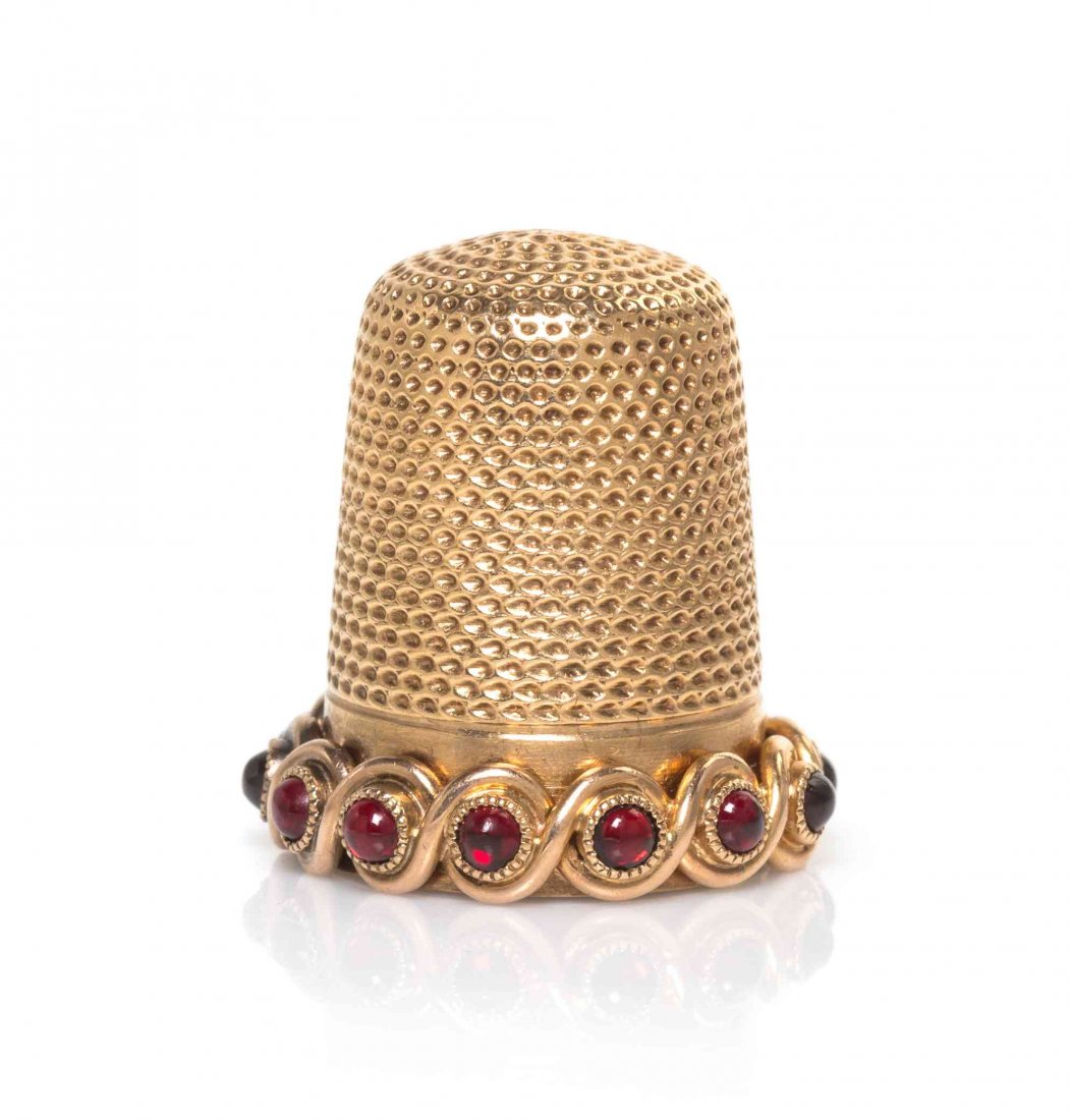 An American 14-Karat Gold and Garnet-Mounted Thimble,: An American 14-Karat Gold and Garnet-Mounted Thimble, SECOND HALF 19TH CENTURY, the rim applied with a guilloche band mounted with cabochon garnets, marked on interior and stamped 14K. Height 13/16 in