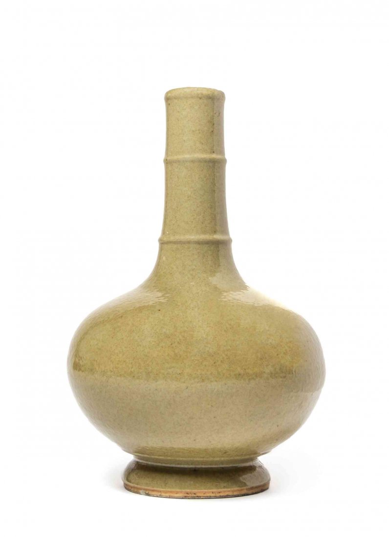 A Chinese Buff Glaze Bottle Vase, Height 11 3/4 inches.: A Chinese Buff Glaze Bottle Vase, having a monochrome glaze throughout, the bottle with two horizontal raised ribs, raised on a circular foot. Height 11 3/4 inches. Condition: In overall good, complet
