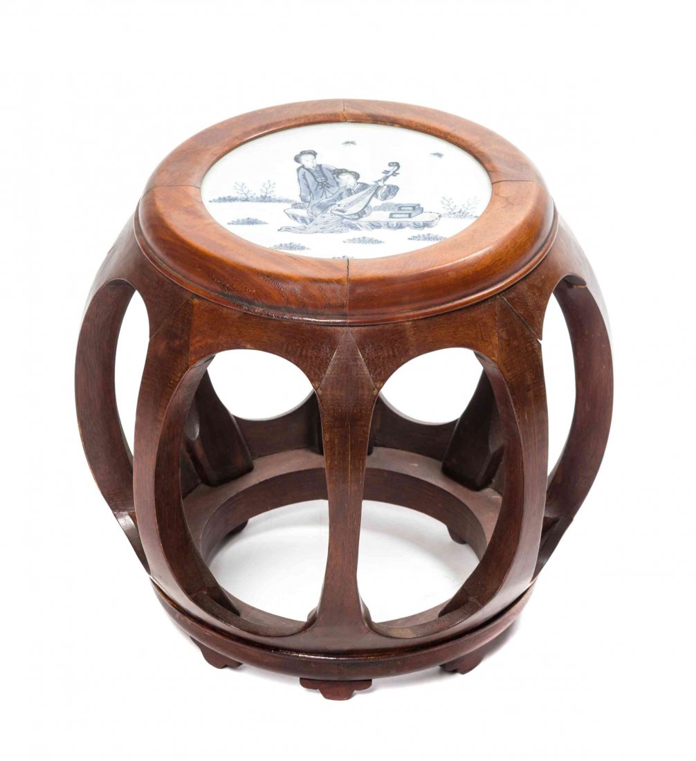 A Porcelain Inset Hardwood Garden Seat, Height 13 3/4: A Porcelain Inset Hardwood Garden Seat, having a blue and white figurally decorated inset circular seat above the openwork barrel fom supports. Height 13 3/4 inches.