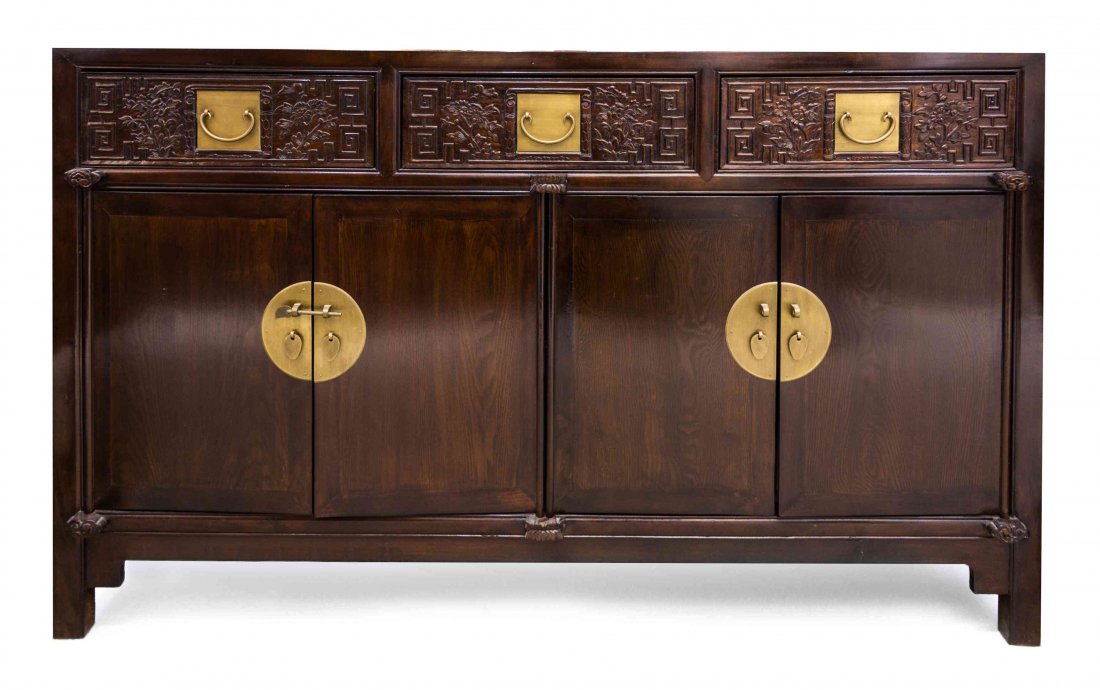 A Chinese Wood Cabinet, Height 37 3/4 x width 61 x: A Chinese Wood Cabinet, having a dark varnished finish, the three drawers with square escutcheon plates and flanked by relief carved foliage and leiwen, above two pairs of cabinet doors with circular 