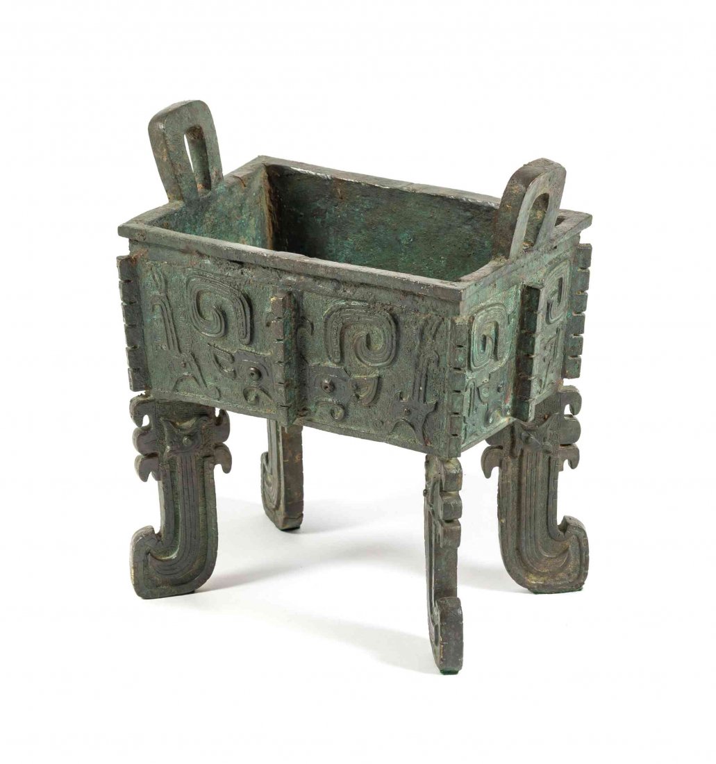 A Chinese Bronze Archaistic Fang Ding, Height 12 1/8: A Chinese Bronze Archaistic Fang Ding, the squared vessel having upright loop handles and relief taotie decoration, with notched vertical flanges, raised on shaped legs. Height 12 1/8 inches. Conditio