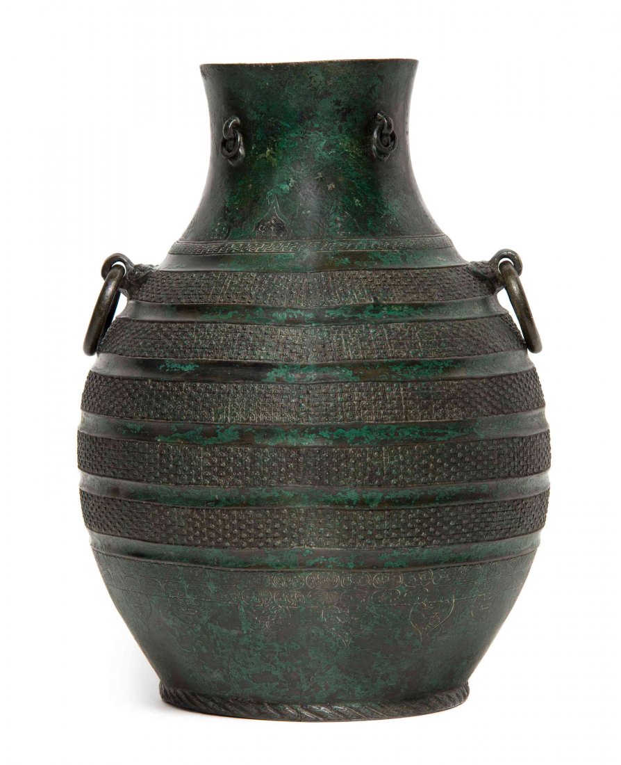 A Chinese Bronze Hu Vessel, Height 12 3/8 inches.: A Chinese Bronze Hu Vessel, Warring States Period (475-221 B.C.E.) of pear form having small ring handles around the neck and ring handles issued from beast masks flanking the shoulder, with horizonta