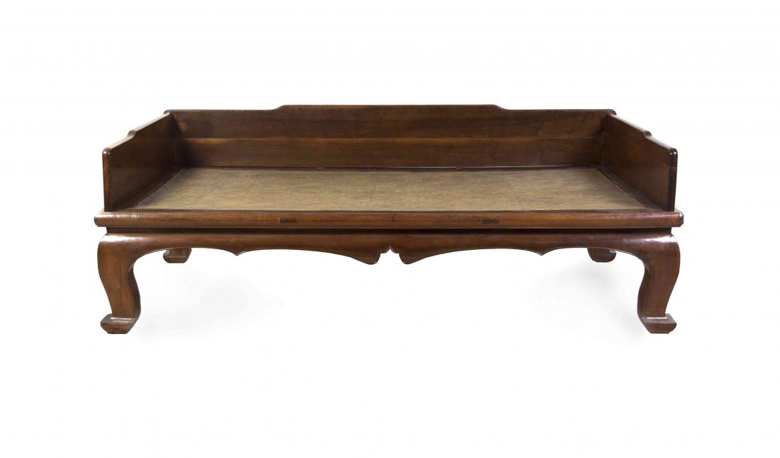 A Chinese Carved Wood Luohan Bed, Height 28 x width 84: A Chinese Carved Wood Luohan Bed, 17th/18th century, having shaped plank back and sides surrounding the mat platform, a scalloped apron and squat curved legs ending in hoof feet. Height 28 x width 84 