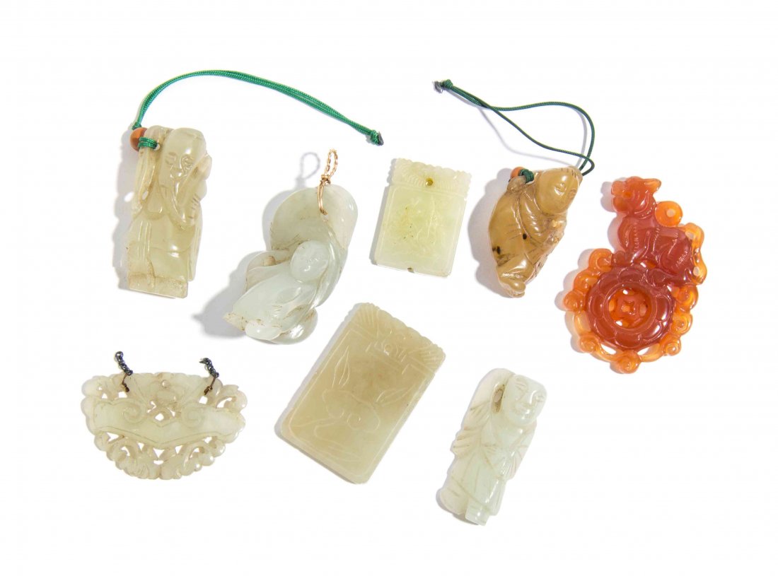 A Group of Seven Carved Jade Articles, Height of: A Group of Seven Carved Jade Articles, comprising figural toggles and rectangular plaques carved in relief, with a pierce carved butterfly, together with a carnelian agate pendant. Height of tallest 2