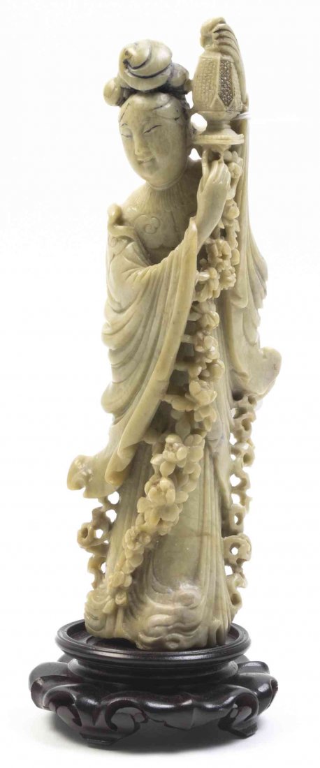 A Carved Soapstone Figure of a Lady, Height 9 inches.: A Carved Soapstone Figure of a Lady, depicted robed and holding a lantern, raised on a fitted wood stand. Height 9 inches.