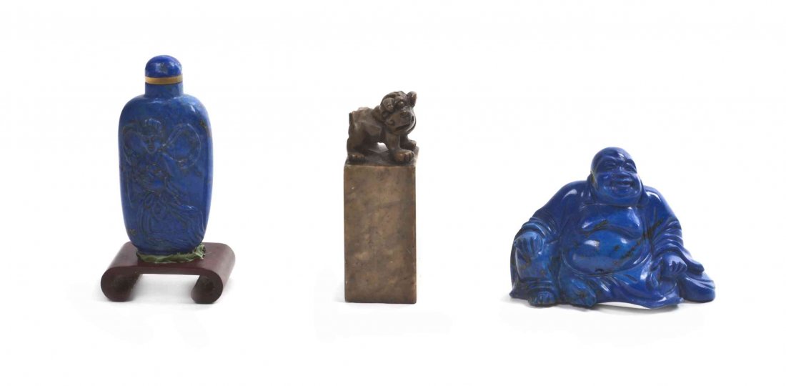 Three Chinese Hardstone Articles, Height of first 2 1/2: Three Chinese Hardstone Articles, comprising a lapis snuff bottle, a lapis figure of a seated Buddha, and a soapstone carved seal stamp, with two wood bases. Height of first 2 1/2 inches. Property fro
