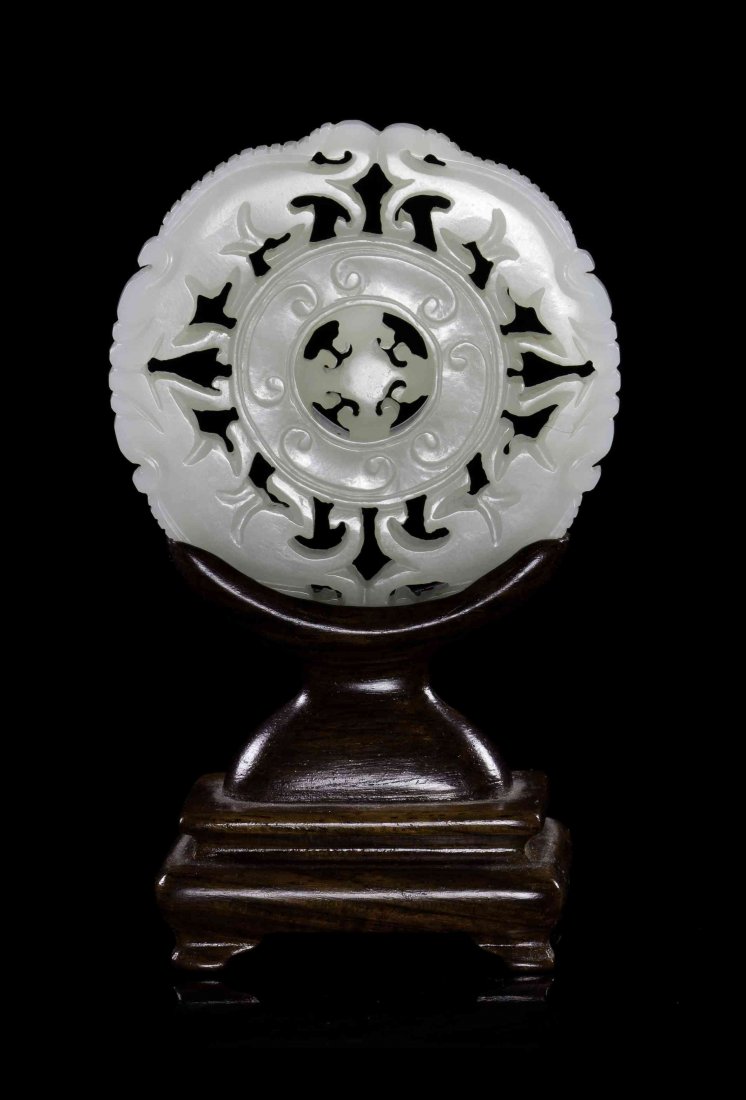 A Carved Jade Disc, Diameter 2 3/8 inches.: A Carved Jade Disc, of a near-white stone, the outer border depicting two pairs of opposed four-legged beasts around a bi with raised C-scrolls, around a center with pierced carved lingzhi fungus form