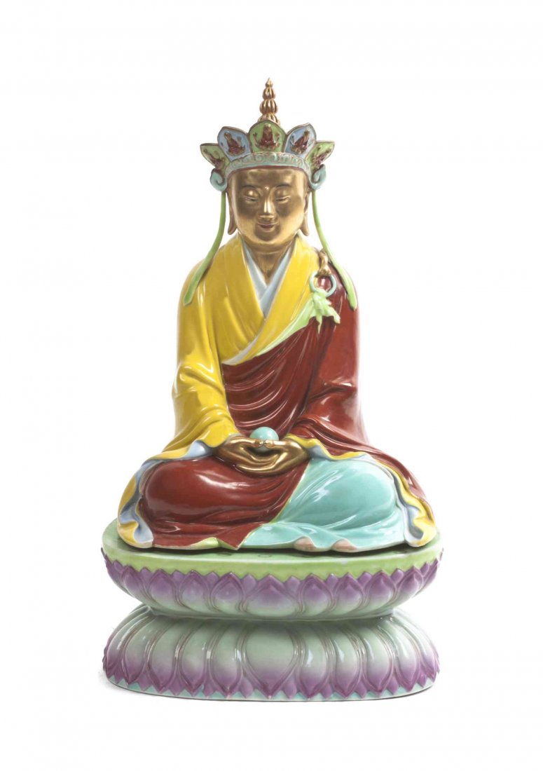 A Chinese Polychrome Decorated Ceramic Figure of a: A Chinese Polychrome Decorated Ceramic Figure of a Lama, the Buddhist figure depicted with tiered, figurally decorated crown, wearing red and yellow robes, raised on a lotus form base. Height 13 3/4 i