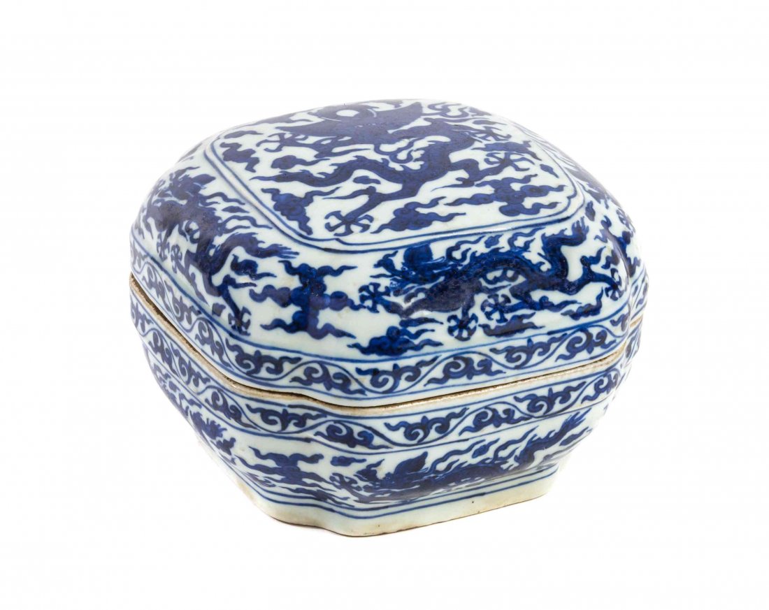 A Blue and White Porcelain Shaped Box and Cover, Width: A Blue and White Porcelain Shaped Box and Cover, decorated with five-clawed dragons, clouds and bands of ruyi, having a six-character Wanli mark to the underside. Width 6 inches.