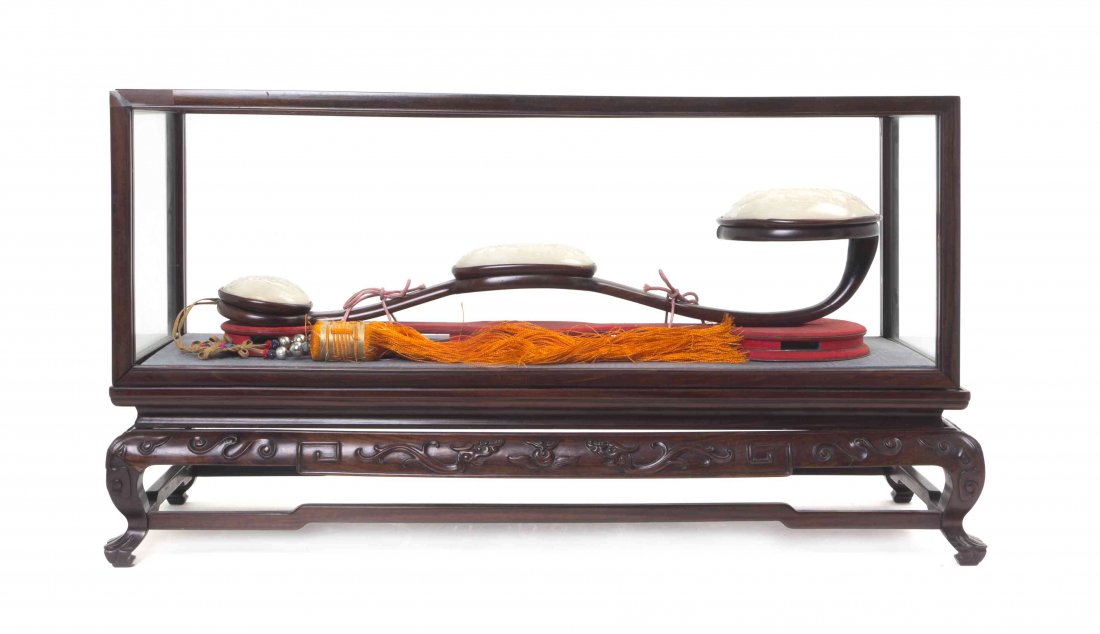 A Hardstone and Wood Ruyi Scepter, Length 21 inches.: A Hardstone and Wood Ruyi Scepter, raised on a carved hardwood stand, with glass display case. Length 21 inches. Property from the Estate of Harvey and Mildred Levy, St. Louis, Missouri