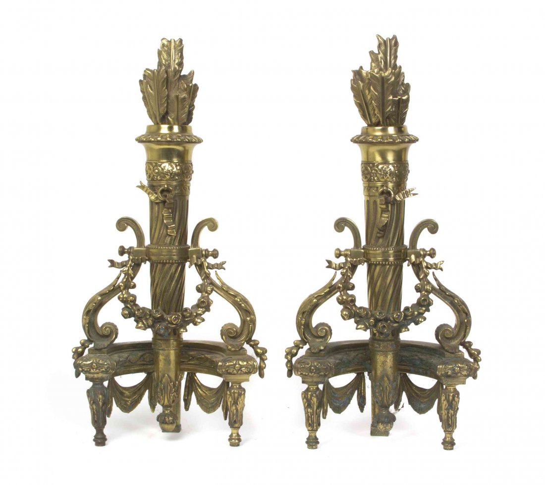 A Pair of Louis XVI Style Bronze Andirons, Height 24: A Pair of Louis XVI Style Bronze Andirons, each in the form of a foliate decorated quiver of arrows, set with foliate decorated S-scroll mounts. Height 24 inches. Property from the Collection of Dan a