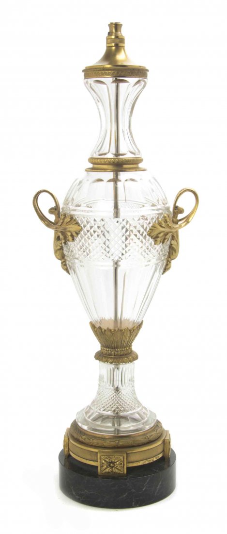 A Continental Gilt Bronze Mounted Cut Glass Urn, Height: A Continental Gilt Bronze Mounted Cut Glass Urn, of baluster form with foliate scroll handles mounted at the shoulders, raised on a circular marble foot, mounted as a lamp. Height overall 36 inches.