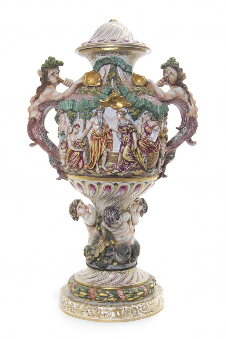 A Capodimonte Porcelain Urn, Height 29 inches.: A Capodimonte Porcelain Urn, of lidded baluster form with mermen handles and a circular foot modeled with three youthful mermen. Height 29 inches.