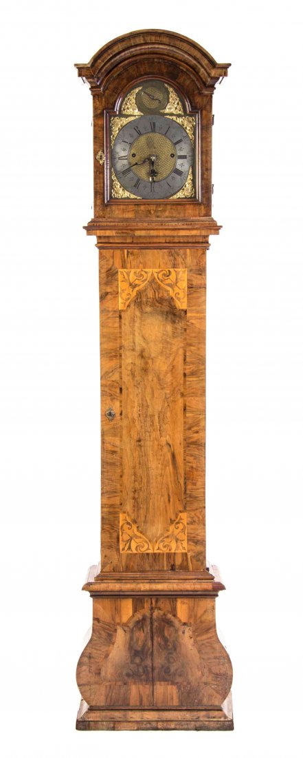 A German Marquetry Inlaid Walnut Tall Case Clock,: A German Marquetry Inlaid Walnut Tall Case Clock, having a circular silver dial with Roman numeral hours, set on a gilt metal face worked to show foliate scrolls and dragon forms, within a shaped case