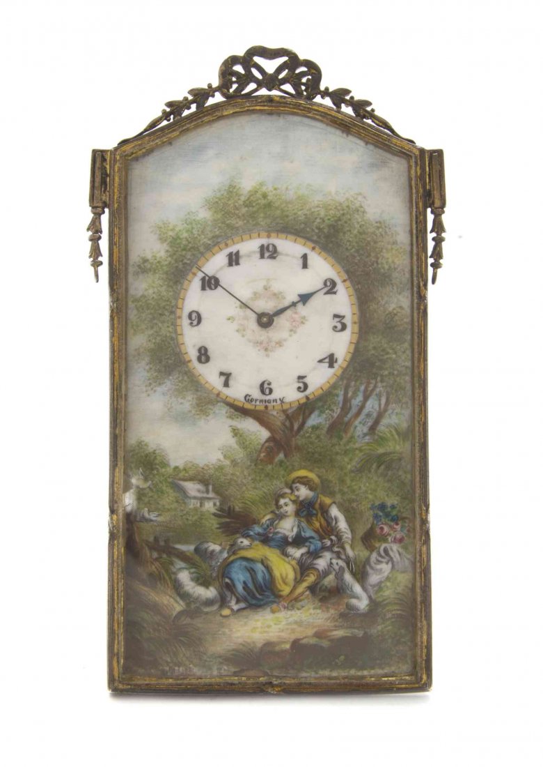 A German Enameled Table Clock, Height 4 3/4 inches.: A German Enameled Table Clock, having a rectangular case with domed top set with a ribbon-tied foliate crest, the face decorated with a courting shepherd and shepherdess, the dial with Arabic numerals