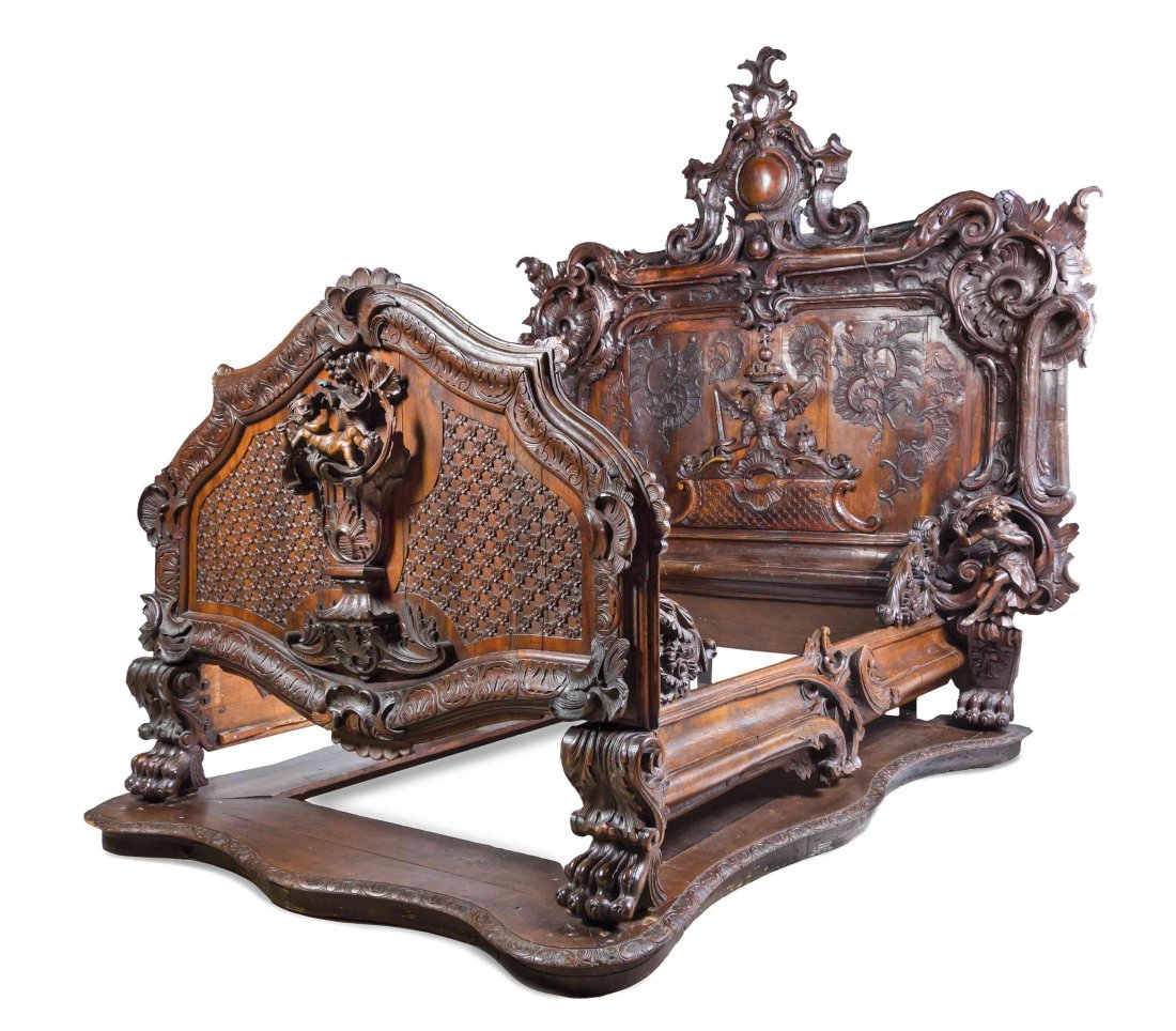 A Baroque Revival Carved Oak and Walnut Bed, Height of: A Baroque Revival Carved Oak and Walnut Bed, PROBABLY AUSTRIAN, 19TH CENTURY WITH EARLIER AND LATER ELEMENTS, carved throughout to show a crowned eagle and foliate scrolls with figures and a putto blo