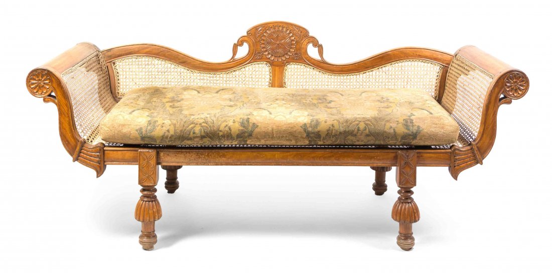 A Victorian Cane Upholstered Walnut Settee, 19TH: A Victorian Cane Upholstered Walnut Settee, 19TH CENTURY, having a shaped back flanked by outwardly scrolling arms over a lift-off cushion seat, raised on turned feet. Width 86 inches. Property from t