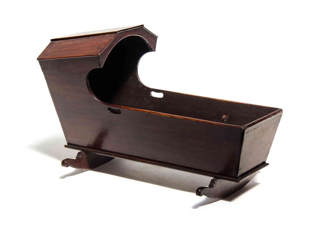 An American Hooded Mahogany Cradle, Length 41 inches.: An American Hooded Mahogany Cradle, of typical form, raised on two conforming rockers. Length 41 inches. Property from the Chicago Historical Society, Chicago, Illinois