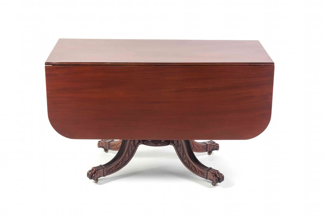An American Mahogany Drop-Leaf Table, ATTRIBUTED TO: An American Mahogany Drop-Leaf Table, ATTRIBUTED TO DUNCAN PHYFE, having a rectangular top flanked by D-shaped leaves above a pineapple carved support, raised on a quadripod base with splayed foliate