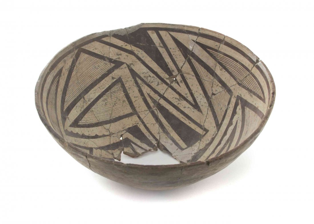 A Southwest Native American Earthenware Bowl, Diameter: A Southwest Native American Earthenware Bowl, painted to show a geometric pattern throughout. Diameter 11 7/8 inches. Condition: Broken and reglued throughout, with the bottom section missing.