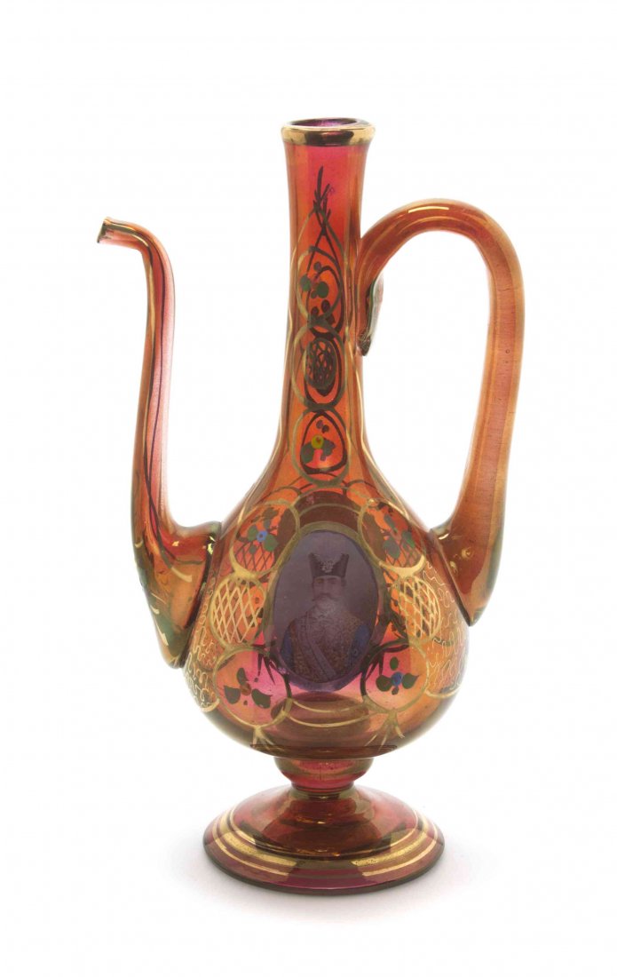 A Qajar Ruby Glass Ewer, 19TH/20TH CENTURY, Height 10: A Qajar Ruby Glass Ewer, 19TH/20TH CENTURY, of baluster form, transfer printed to show a portrait of Shah Nasr-al-din and painted to show floral sprays and arabesques, raised on a circular foot. Heigh