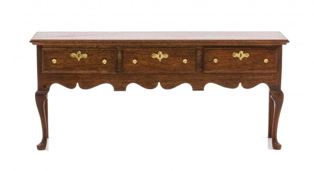 An English Provincial Style Mahogany Sideboard, Height: An English Provincial Style Mahogany Sideboard, ROGER L. GUTHEIL, 1983, having a rectangular top with a molded edge over three drawers and a shaped apron, raised on cabriole fore-legs ending in pad fe