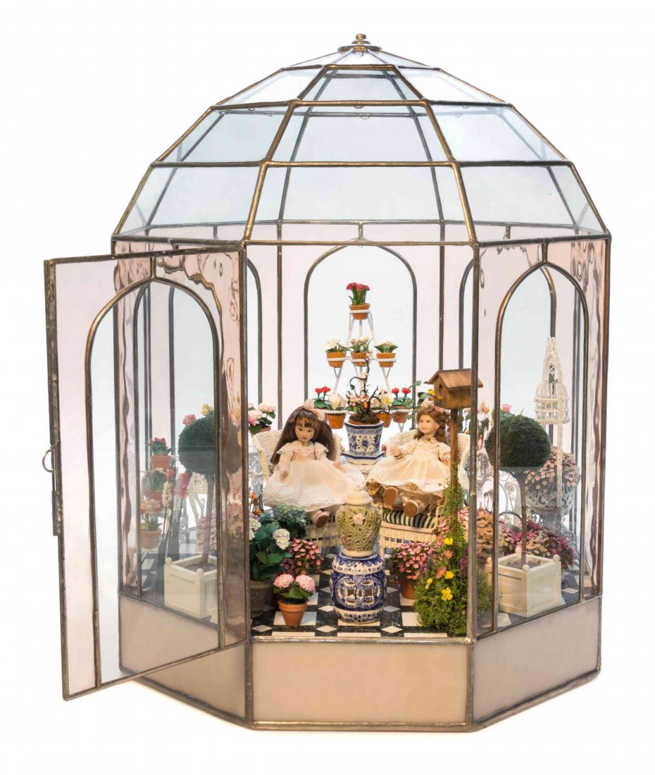 A Lady Jane Glass Conservatory, Height 16 x diameter 12: A Lady Jane Glass Conservatory, LINDA YOUNG AND OTHERS, of domed octagonal form, enclosing two dolls, a pair of wicker chairs by Bob and Nan Rankin, a wicker table by Rhea Strange, a group of white pa