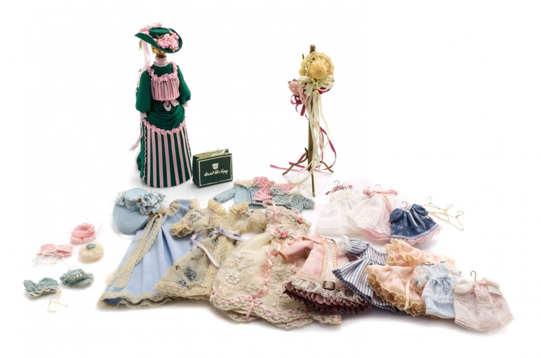 A Collection of Doll Clothes and Accessories, Hight of: A Collection of Doll Clothes and Accessories, comprising dresses of varying lengths, blouses, sweaters, hats, gloves, hangers, a coat rack, a shopping bag and a clothed form; 36 items total. Hight of
