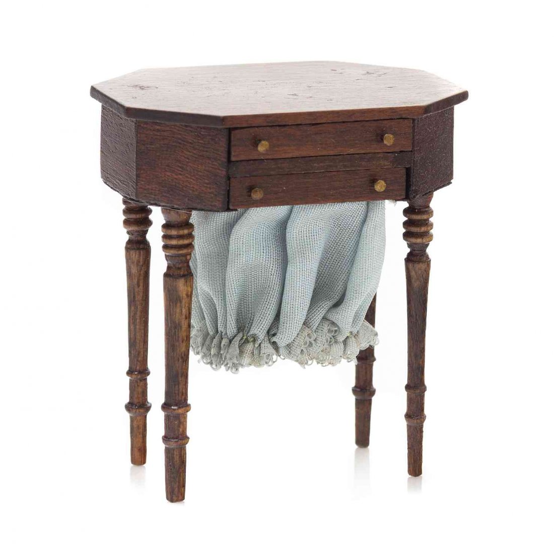 A Sheraton Style Sewing Table, Height 2 3/8 x width 2: A Sheraton Style Sewing Table, MARTY DINKEL, having an elongated hexagonal top over two drawers, one with a pull-out basket, raised on turned tapering legs. Height 2 3/8 x width 2 1/8 x depth 1 5/8 in