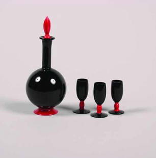 A Four Piece Glass Decanter Set,: A Four Piece Glass Decanter Set, comprising a stoppered bottle and three cordials, eachin black and red glass.Height of bottle 9 3/4 inches.
