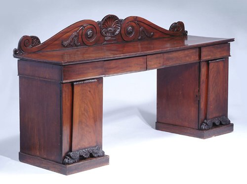 REGENCY MAHOGANY PEDESTAL SIDEBOARD Ca. 1: REGENCY MAHOGANY PEDESTAL SIDEBOARD Ca. 1820 The raised shell and acanthus carved shaped back over four frieze drawers, the breakfront pedestals carved with lions paw feet and opening to reveal shelve