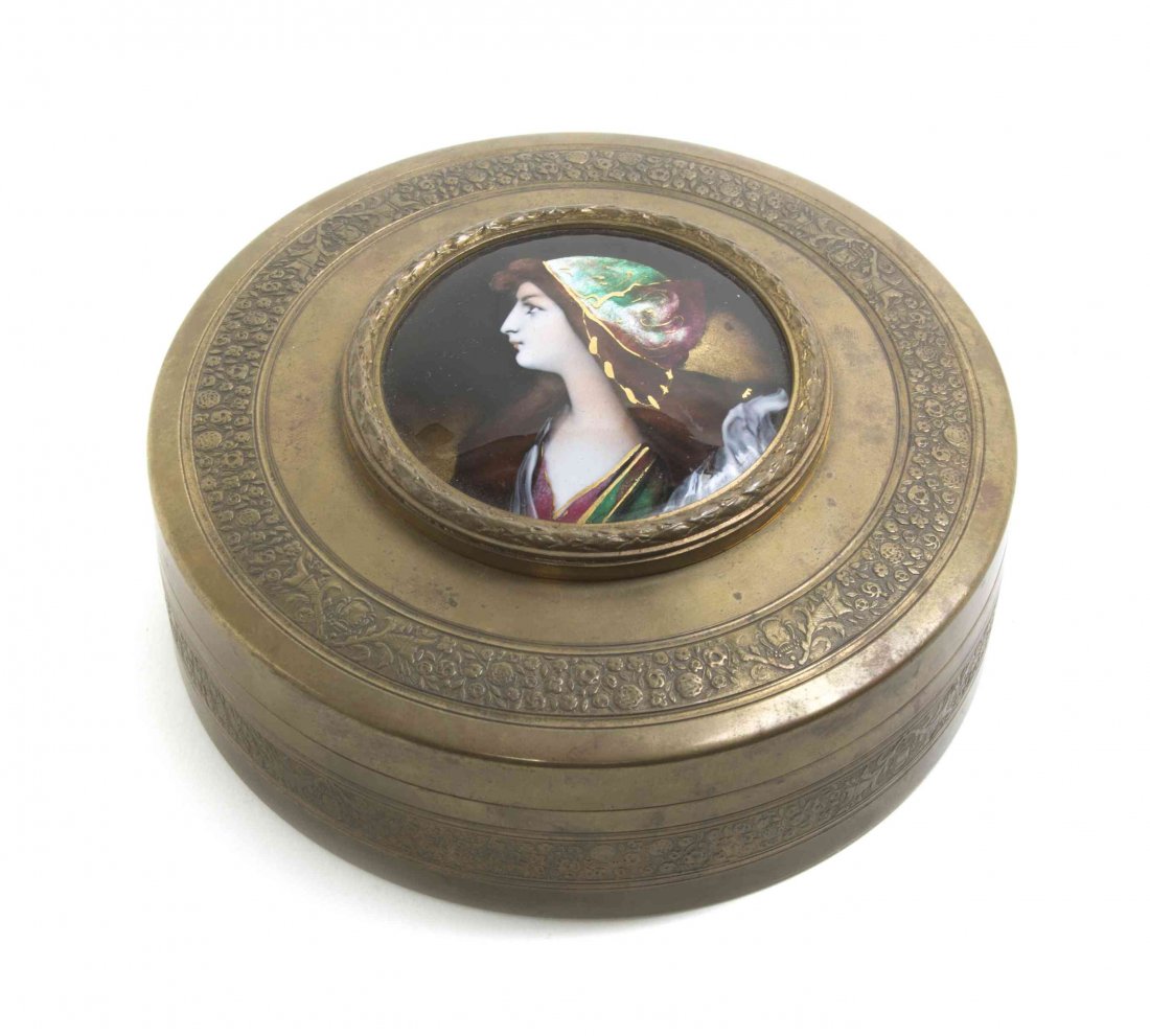 A French Enameled Plaque, Diameter of box 5 1/2 inches.: A French Enameled Plaque, of circular form depicting a maiden, set in a circular brass box. Diameter of box 5 1/2 inches. Property from the Estate of a Prominent Midwest Collector
