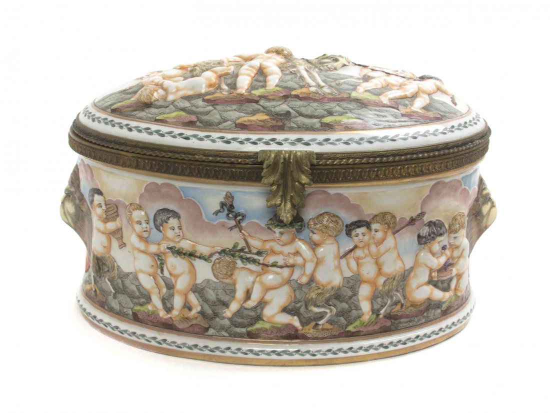 A Capodimonte Porcelain Table Casket, Width 14 1/2: A Capodimonte Porcelain Table Casket, of oval form with a hinged lid and lion masks at the sides. Width 14 1/2 inches. Property from the Estate of a Prominent Midwest Collector