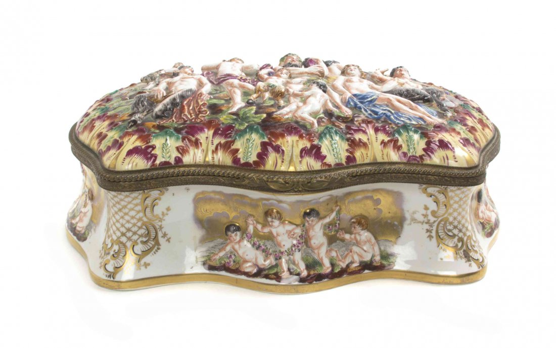 A Capodimonte Porcelain Table Casket, Width 16 7/8: A Capodimonte Porcelain Table Casket, with a hinged lid depicting a Bacchic scene, the interior painted to show a bouquet of flowers. Width 16 7/8 inches. Property from the Estate of a Prominent Midwe