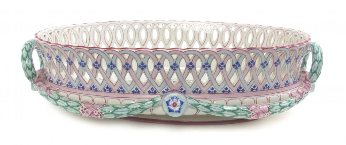 A French Faience Centerpiece Bowl, Width 16 3/4 inches.: A French Faience Centerpiece Bowl, having a reticulated rim and wreath form handles, the interior worked to show a bouquet of flowers. Width 16 3/4 inches.