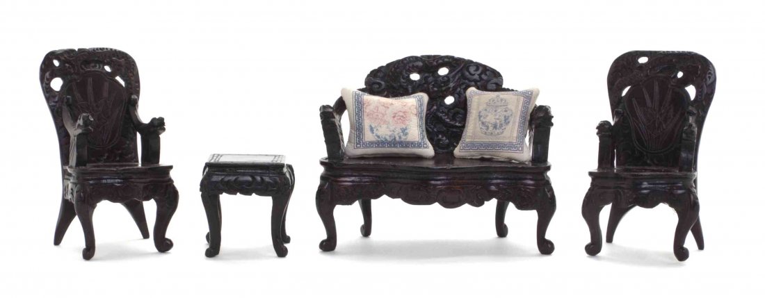 A Suite of Diminutive Chinese Style Rosewood Furniture,: A Suite of Diminutive Chinese Style Rosewood Furniture, comprising a settee and two armchairs having carved dragon and iris decoration, and a matching end table, each retaining a tag to underside decl