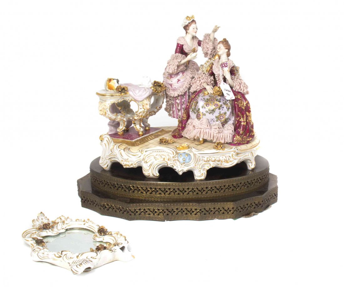 A Continental Porcelain Figural Group, Width 16 1/2: A Continental Porcelain Figural Group, depicting two ladies wearing dresses with lace trim next to a dressing table and mirror, now detached, raised on a stepped gilt metal base. Width 16 1/2 inches. 