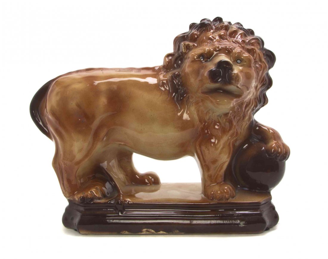 A Staffordshire Pottery Model of a Medici Lion, Width: A Staffordshire Pottery Model of a Medici Lion, depicted with one paw raised on a ball. Width 14 1/2 inches.