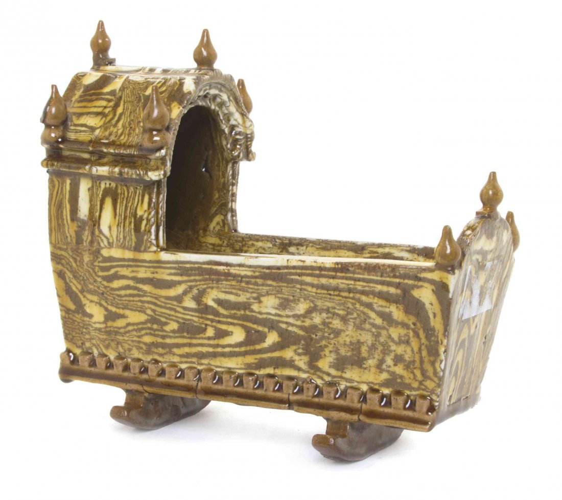 A Marbled Redware Cradle, Height 8 1/4 x width 8 1/2 x: A Marbled Redware Cradle, set on rockers. Height 8 1/4 x width 8 1/2 x depth 3 inches.