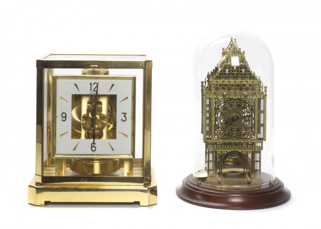 A Swiss Brass Atmos Clock, Le Coultre, Height of first: A Swiss Brass Atmos Clock, Le Coultre, having a square dial within an octagonal glass case, together with a German desk clock in the form of a cathedral. Height of first 9 1/4 x width 8 1/4 inches. Pr