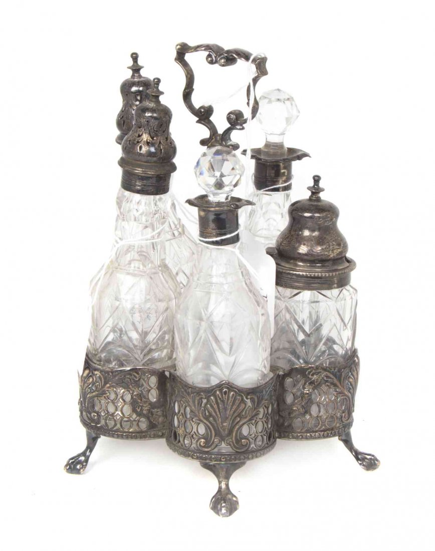 A Victorian Silver and Cut Glass Cruet Set, Charles: A Victorian Silver and Cut Glass Cruet Set Charles Thomas Fox & George Fox, London, 1851 the stand with five circular sections for bottles chased with anthemions and pierced concentric circles, surmou