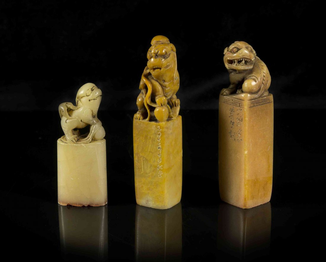 A Group of Three Chinese Carved Stone Seal Stamps,: A Group of Three Chinese Carved Stone Seal Stamps, each carved from soapstone and surmounted with a temple lion. Height of tallest 3 3/4 inches. Condition: Each in overall fair condition, having minor