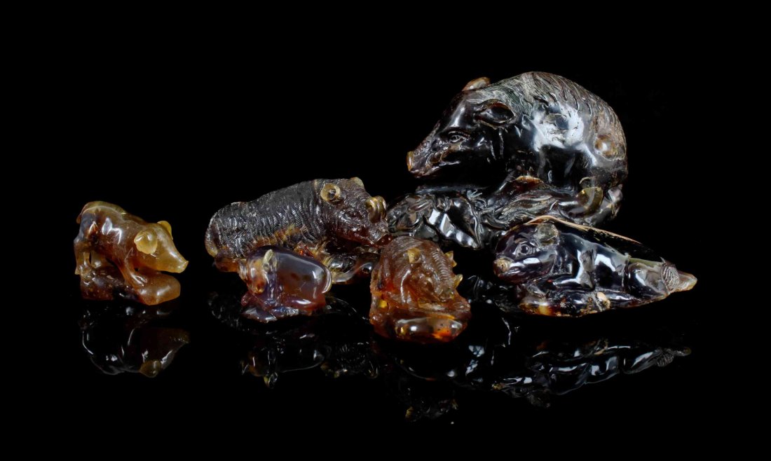 A Collection of Amber Pig Carvings,, Indonesia,, carved: A Collection of Amber Pig Carvings, Indonesia, carved from amber sourced from Indonesia, the colors ranging from yellow to green and blue, realistically depicting various pigs and wild boars. Length o